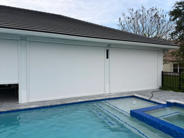 Exterior retractable screens enclosing a poolside covered patio